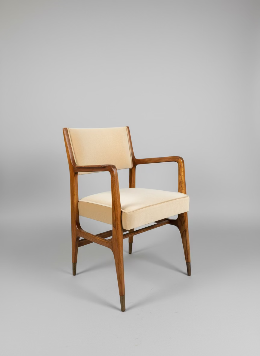Wooden armchair with beige cushion against a gray wall from an angle.