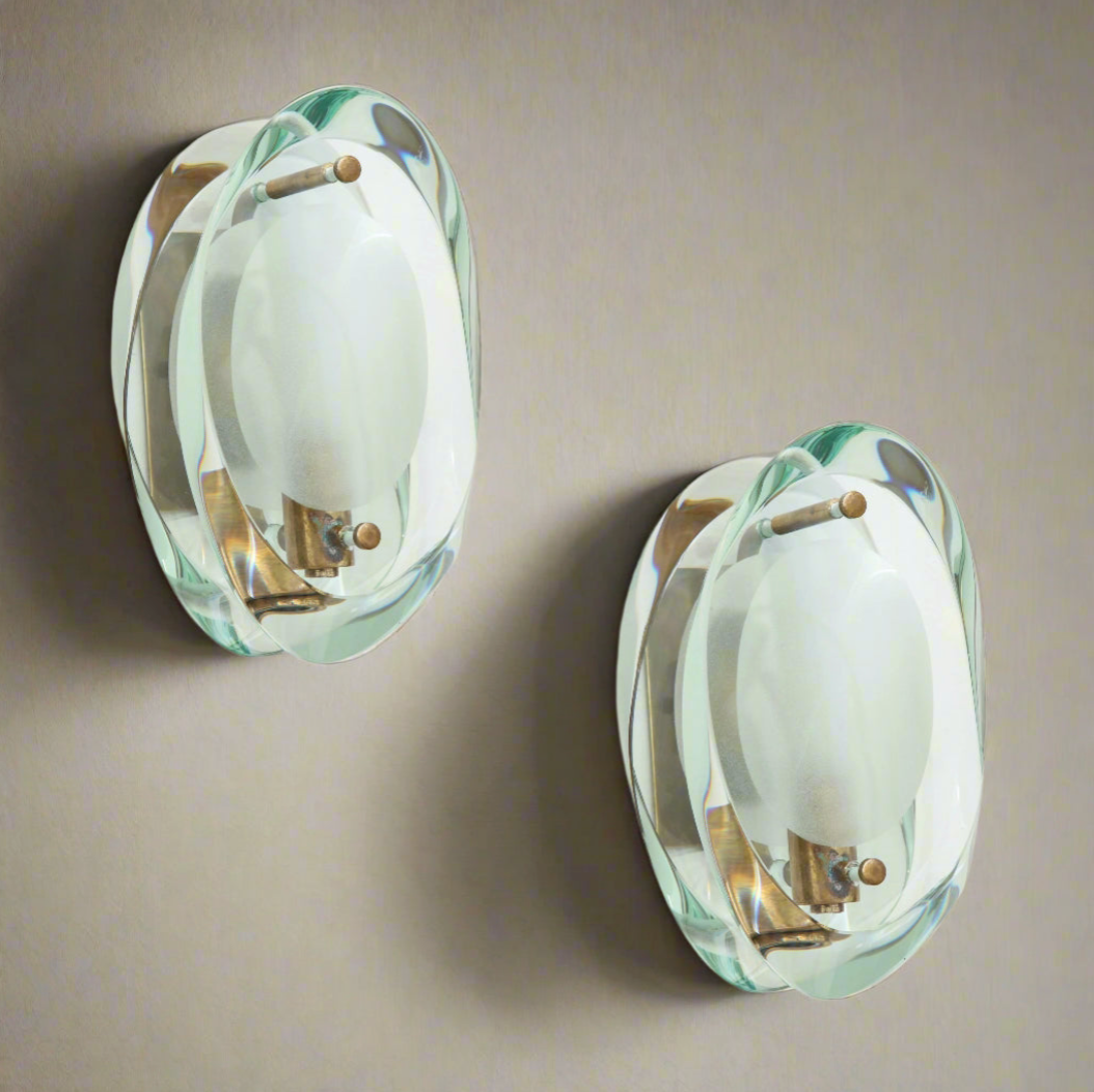 Two wall-mounted sconces with glass shades on a neutral background